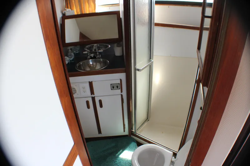 Slide: The Image of 1986 Carver 3297 Mariner bathroom with sink, mirror, shower, and toilet. - 10