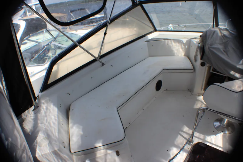 Slide: The Image of 1986 Carver 3297 Mariner boat interior with white seating and windows. - 13