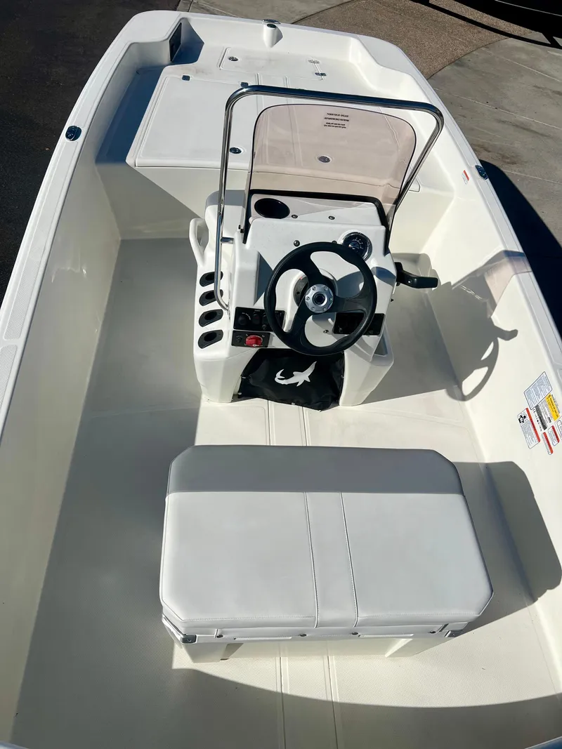 Slide: The Image of 2024 Mako Pro Skiff 17 CC center console boat interior with steering wheel and seating. - 3