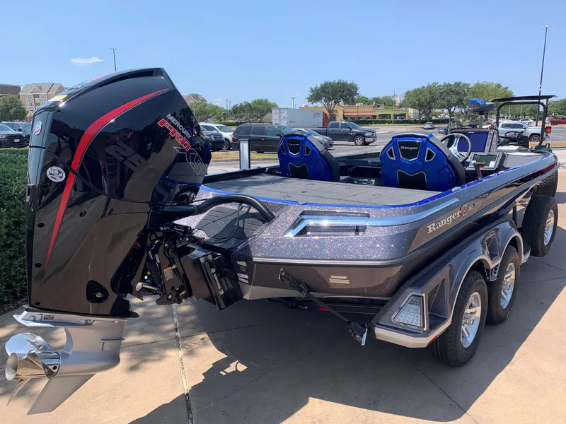 Slide: The Image of 2024 Ranger Z521R boat with powerful outboard motor in a parking lot. - 2