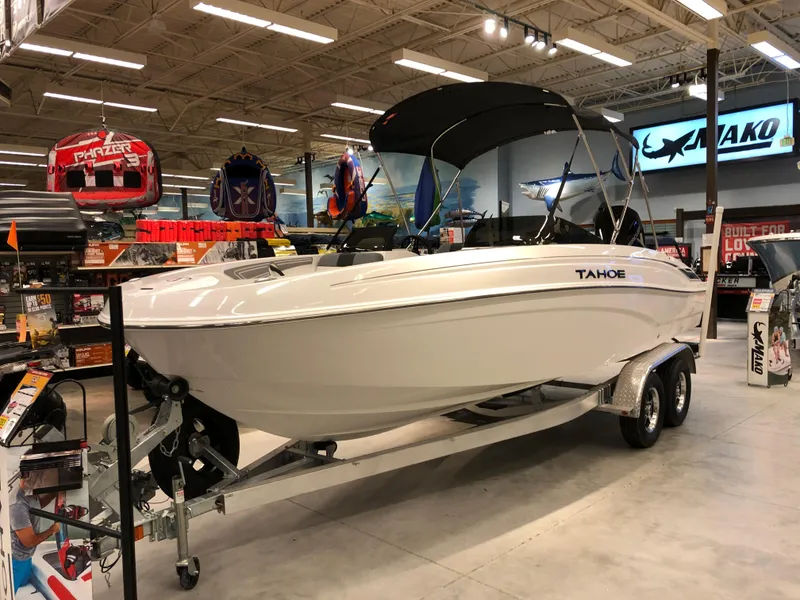 Slide: The Image of 2024 Tahoe T21 boat on display in a showroom with accessories. - 0