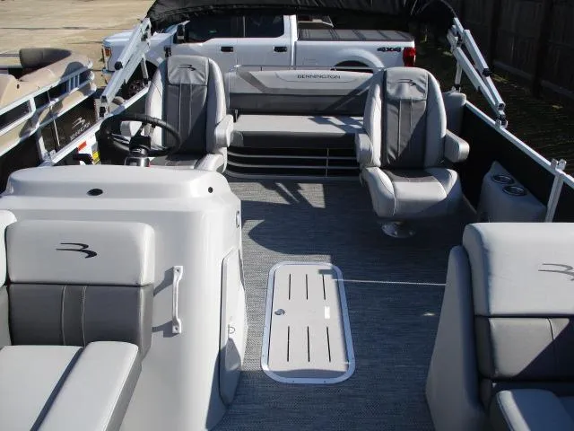 Slide: The Image of 2024 Bennington 22SXSB pontoon boat interior with gray seating and steering console. - 7