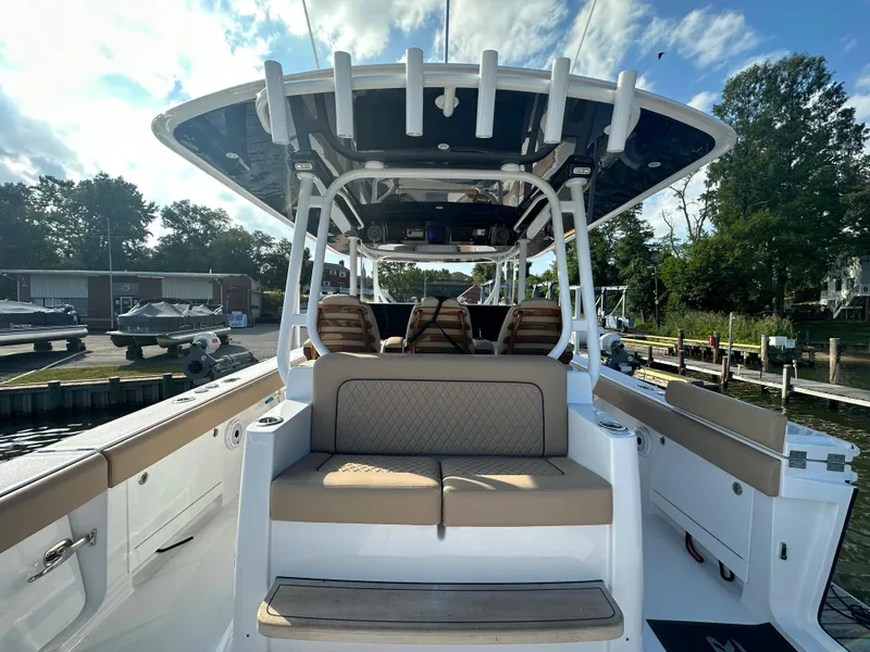 Slide: The Image of 2024 Jupiter 43 boat with cushioned seating and modern design at a marina. - 12