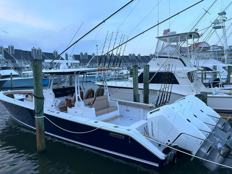 Slide: The Image of 2024 Jupiter 43 boat docked at marina with fishing rods. - 2