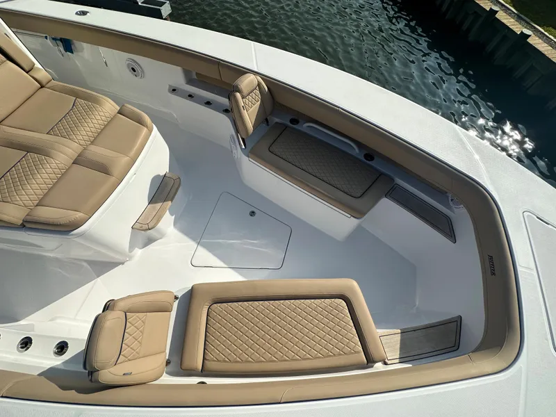 Slide: The Image of Luxurious seating area on the 2024 Jupiter 43 boat, featuring tan and white upholstery. - 49