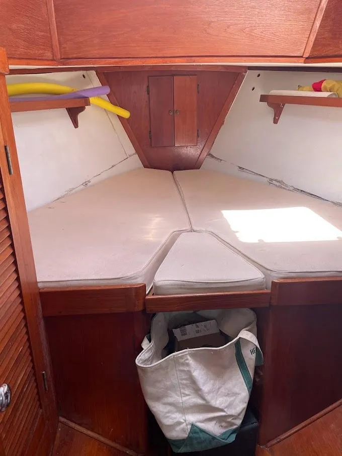 Slide: The Image of 1977 Gulfstar 37 sailboat interior cabin with V-berth and wooden storage shelves. - 10