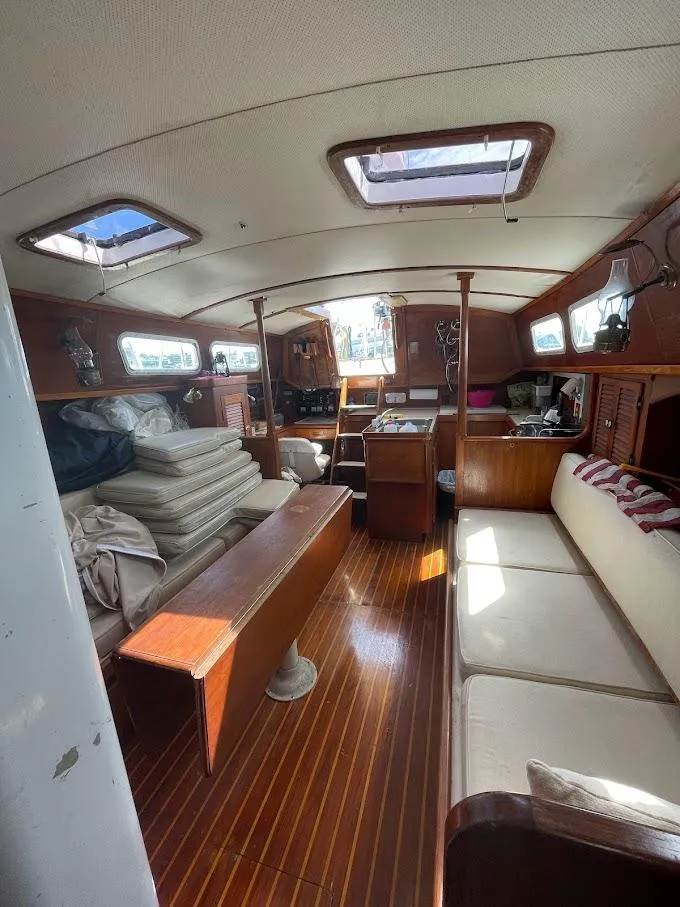 Slide: The Image of Interior of a 1977 Gulfstar 37 sailboat with wooden furnishings and natural light. - 12