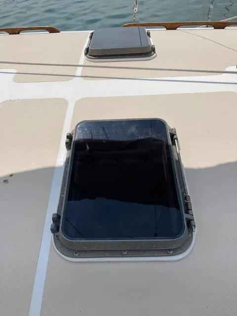 Slide: The Image of 1977 Gulfstar 37 sailboat deck with closed hatch, docked on calm water. - 14