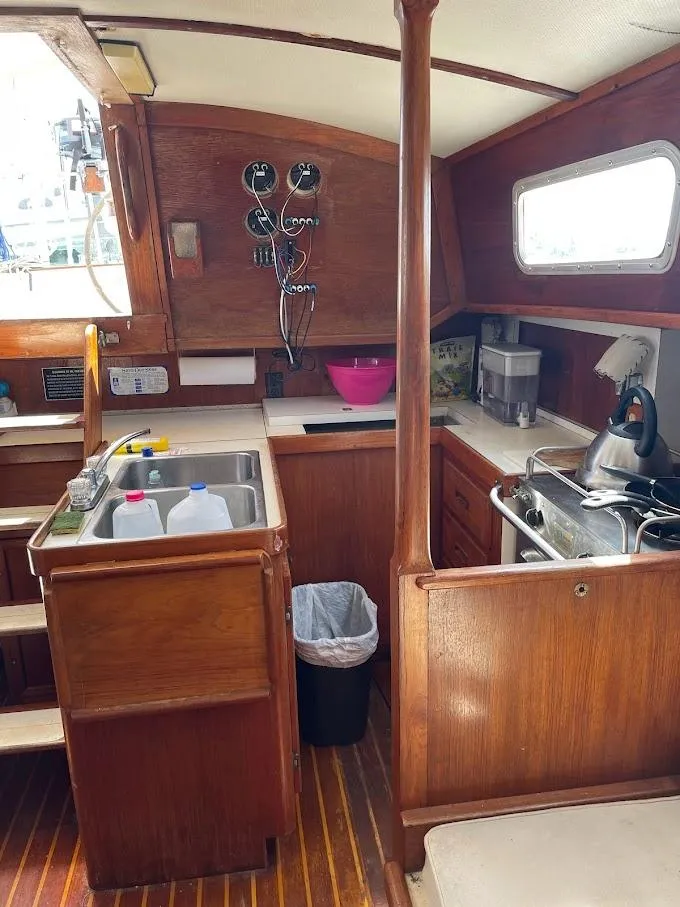 Slide: The Image of 1977 Gulfstar 37 yacht interior with wooden cabinetry, kitchen sink, and appliances. - 7