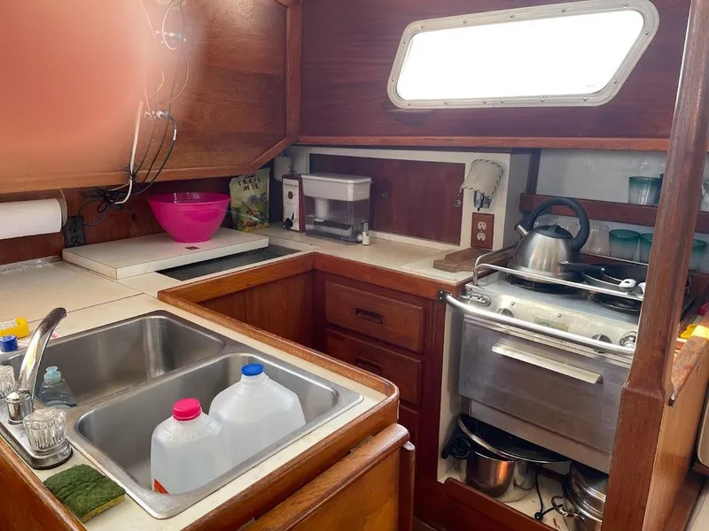 Slide: The Image of 1977 Gulfstar 37 sailboat galley with sink, stove, and storage cabinets. - 8