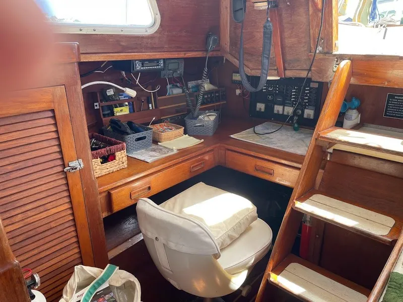 Slide: The Image of 1977 Gulfstar 37 sailboat interior with navigation station, wooden cabinetry, and seating. - 9