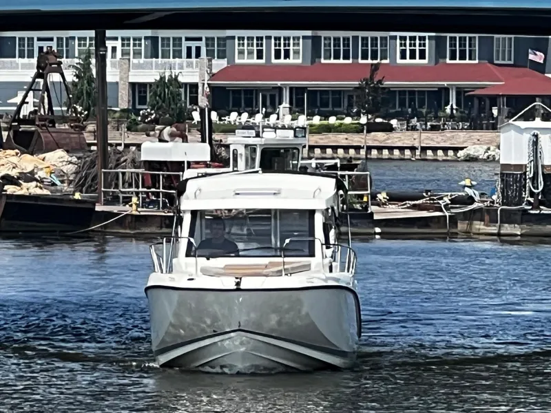 Slide: The Image of 2023 Quicksilver 675 Weekend Cruiser on a river near a dock and buildings. - 4