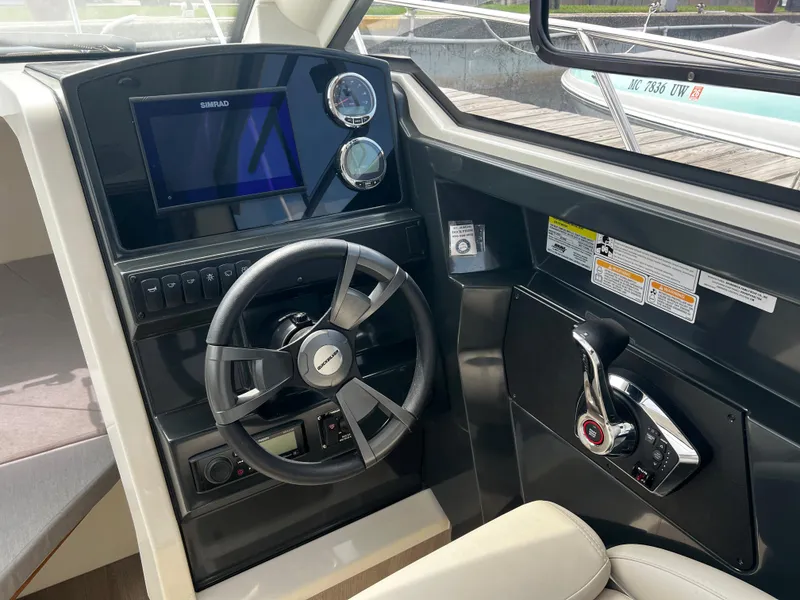 Slide: The Image of 2023 Quicksilver 675 Weekend Cruiser helm with steering wheel and control panel. - 5