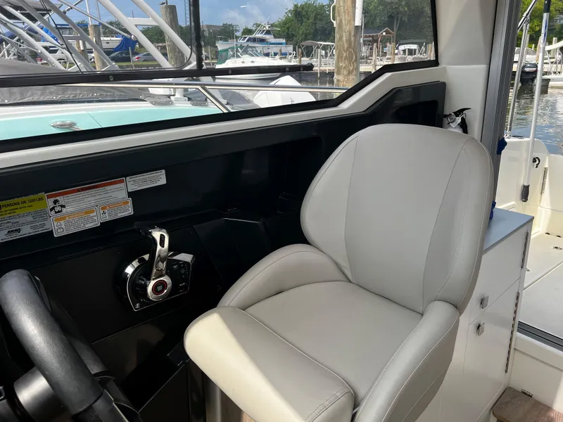 Slide: The Image of 2023 Quicksilver 675 Weekend Cruiser helm seat and controls, docked at marina. - 7