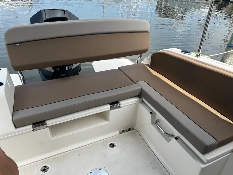Slide: The Image of 2023 Quicksilver 675 Weekend Cruiser boat seating area with brown cushions. - 8