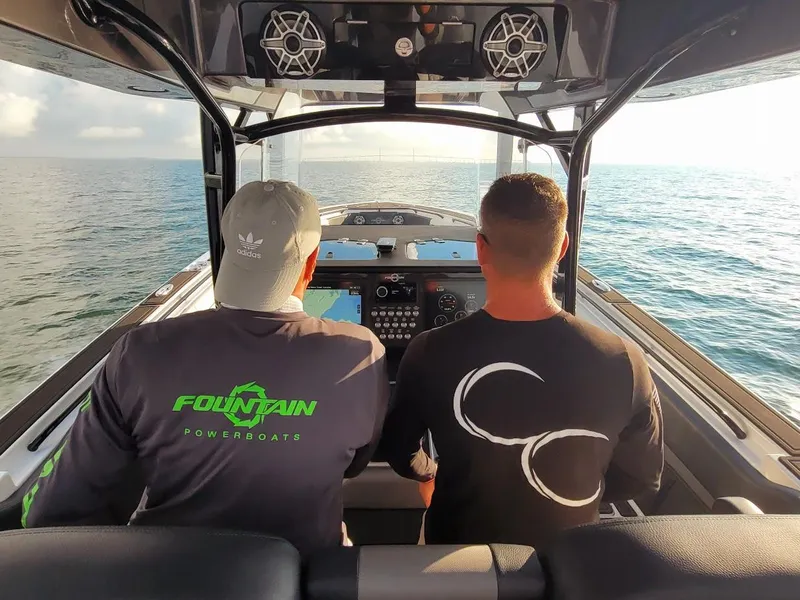 Slide: The Image of Two people navigating a 2025 Fountain 38 SC powerboat on open water. - 25