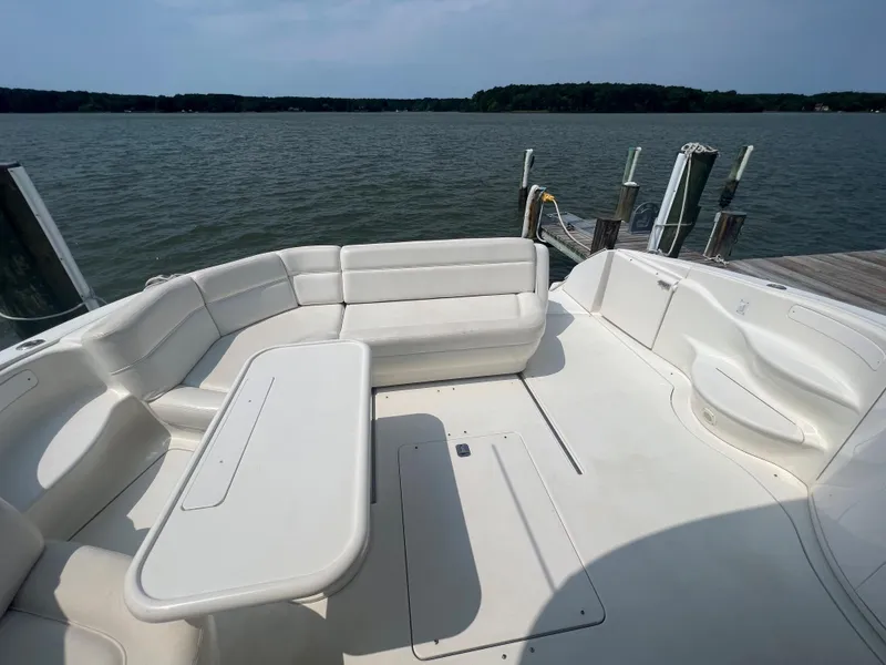 Slide: The Image of Sea Ray 540 Sundancer 2000 boat with spacious white seating area by the water. - 2