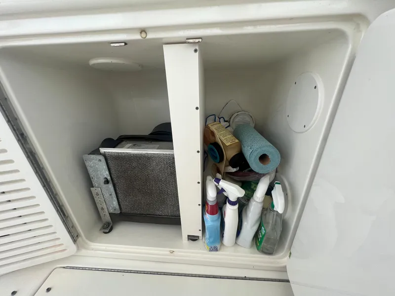 Slide: The Image of Storage compartment on a 2000 Sea Ray 540 Sundancer with cleaning supplies and equipment. - 34