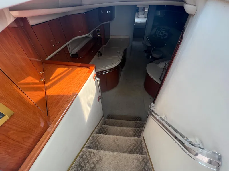 Slide: The Image of Interior of 2000 Sea Ray 540 Sundancer yacht with wooden cabinetry and carpeted stairs. - 36