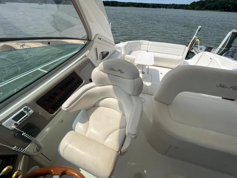 Slide: The Image of 2000 Sea Ray 540 Sundancer cockpit with white leather seating and lake view. - 4