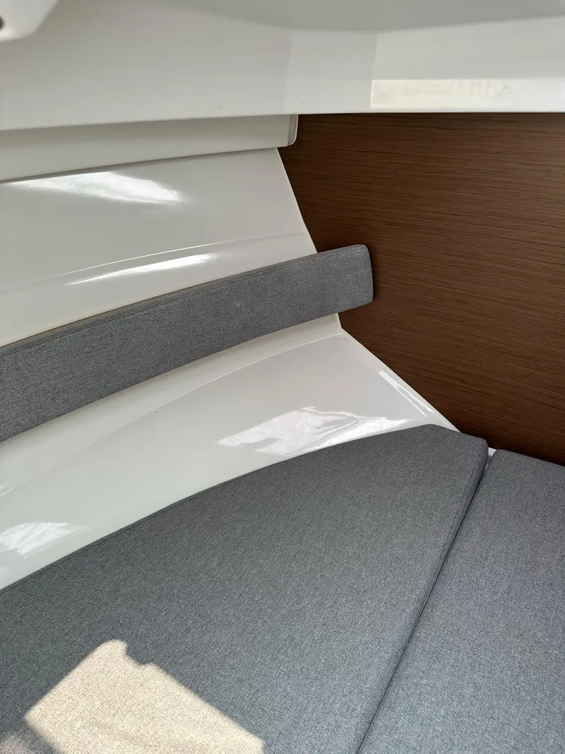 Slide: The Image of Interior cabin of 2020 Beneteau Antares 8 OB with grey cushions and wooden paneling. - 16