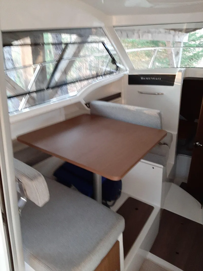 Slide: The Image of 2020 Beneteau Antares 8 OB cabin interior with dining table and seating. - 8