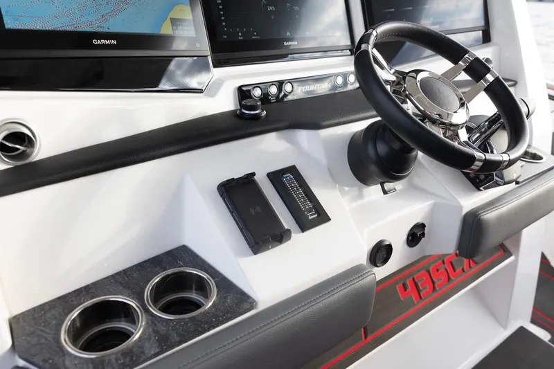 Slide: The Image of 2025 Fountain 43 SCX boat dashboard with steering wheel and navigation screens. - 6