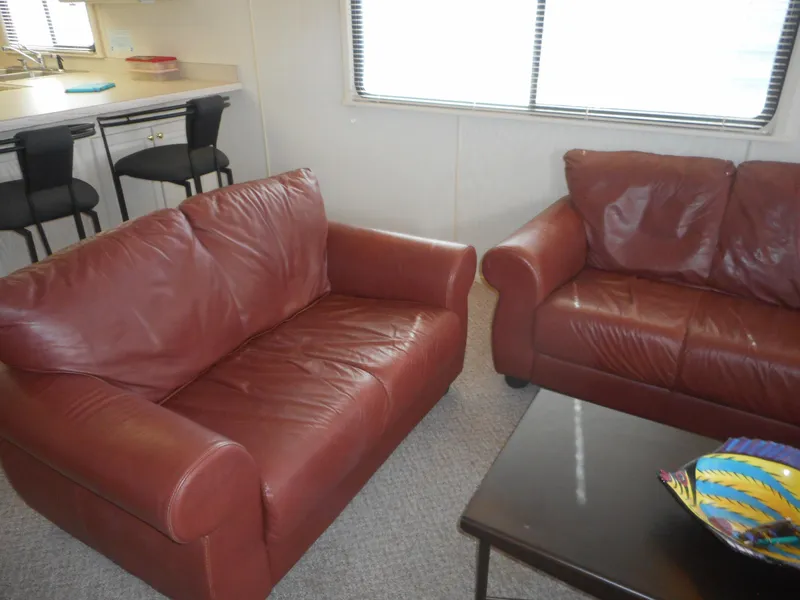 Slide: The Image of Red leather sofas in the living area of a 1995 Stardust Cruisers houseboat, model The Verdict. - 33