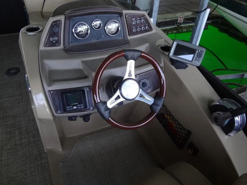 Slide: The Image of 2019 Lowe Retreat 230 RFL boat dashboard with steering wheel and navigation instruments. - 14