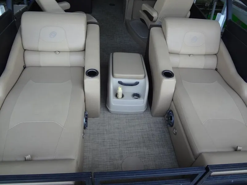 Slide: The Image of 2019 Lowe Retreat 230 RFL interior with beige seating and center console. - 19