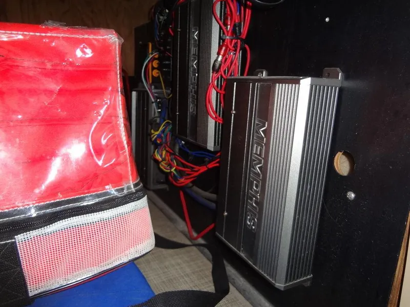 Slide: The Image of 2019 Lowe Retreat 230 RFL boat audio system with Memphis amplifiers and red storage bag. - 24