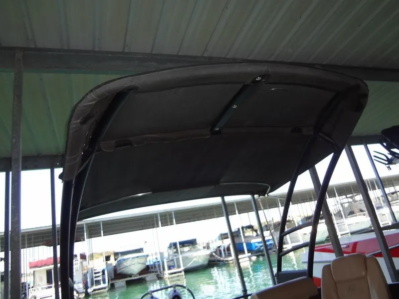 Slide: The Image of 2019 Lowe Retreat 230 RFL boat under covered dock with other boats in background. - 28