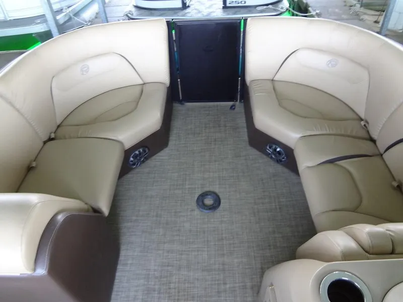 Slide: The Image of 2019 Lowe Retreat 230 RFL pontoon boat interior with beige seating and carpet. - 6