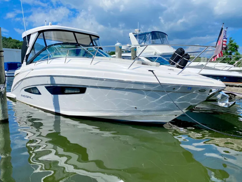 The Image of 2019 Regal 33 Express boat docked at a marina on a sunny day. - 0