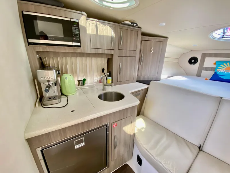 Slide: The Image of 2019 Regal 33 Express cabin interior with white leather seating and wooden table. - 18