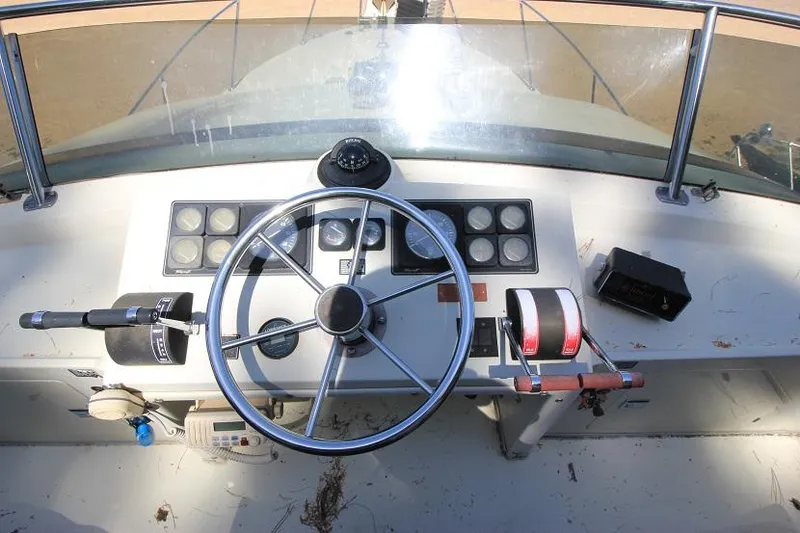 Slide: The Image of 1989 Tollycraft 30 Sport Cruiser helm with steering wheel and control panel. - 11