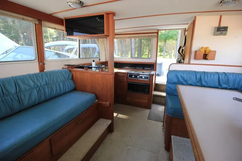 Slide: The Image of Interior of 1989 Tollycraft 30 Sport Cruiser with blue seating and wooden cabinetry. - 12