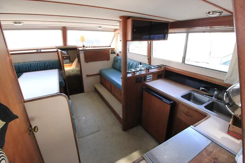 Slide: The Image of Interior of 1989 Tollycraft 30 Sport Cruiser with kitchen, seating, and dining area. - 13