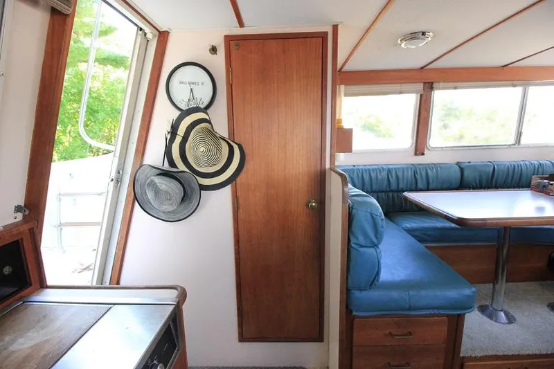 Slide: The Image of Interior of 1989 Tollycraft 30 Sport Cruiser with dining area and hats on wall. - 19