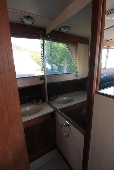Slide: The Image of 1989 Tollycraft 30 Sport Cruiser bathroom with sink and mirror. - 21