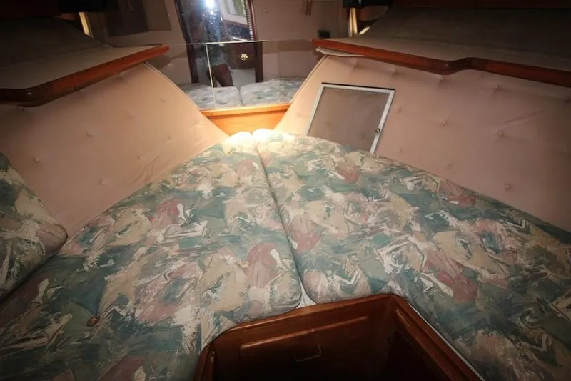 Slide: The Image of 1989 Tollycraft 30 Sport Cruiser cabin interior with patterned bedding and wood accents. - 23