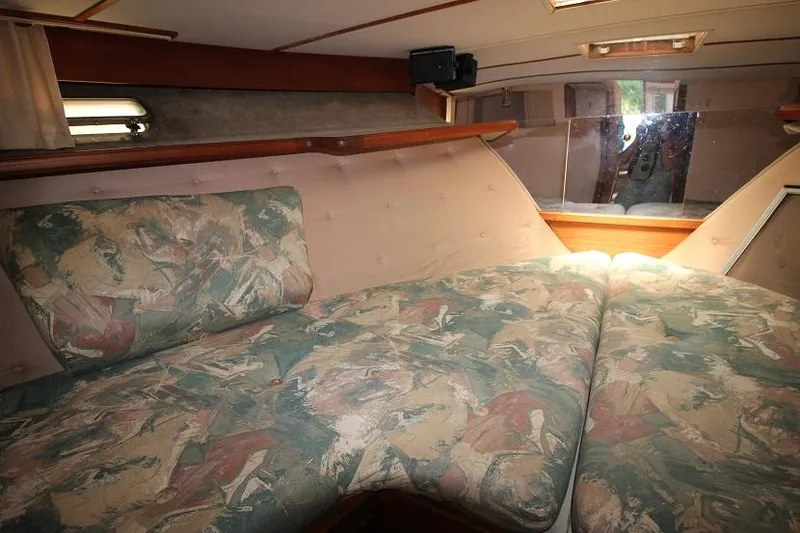 Slide: The Image of 1989 Tollycraft 30 Sport Cruiser cabin with patterned cushions and natural light. - 25