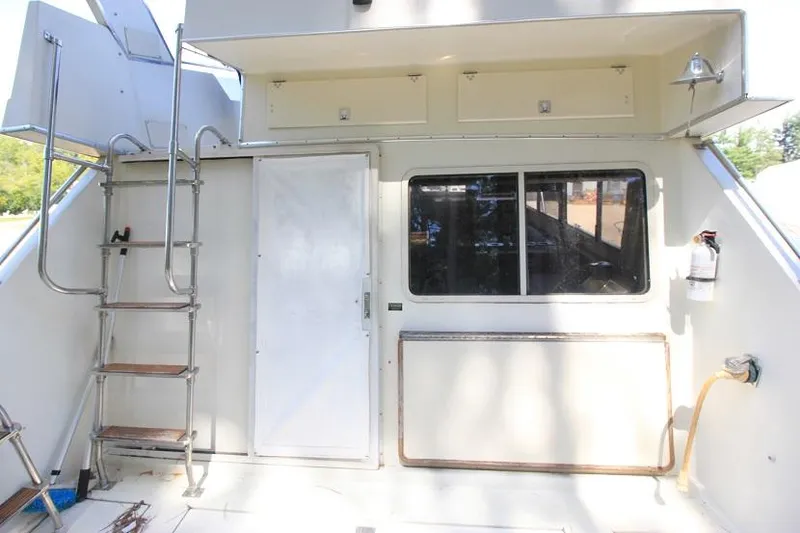 Slide: The Image of 1989 Tollycraft 30 Sport Cruiser rear deck with ladder and door. - 5