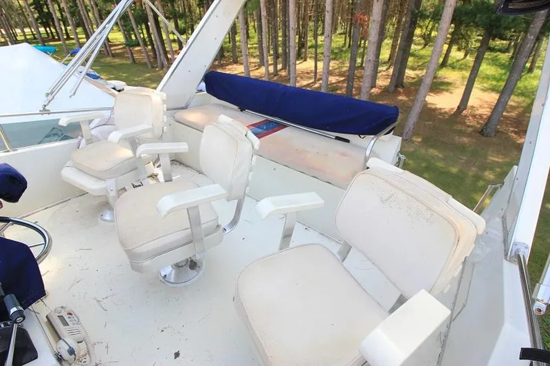 Slide: The Image of 1989 Tollycraft 30 Sport Cruiser flybridge with white captain chairs. - 9