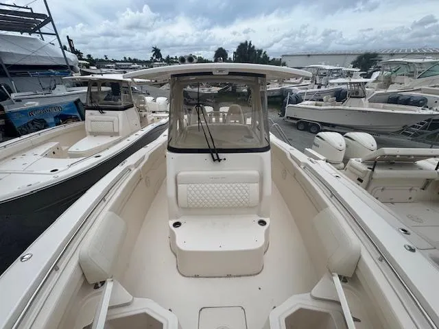 Slide: The Image of 2024 Grady-White Canyon 306 boat, spacious deck, marina background, cloudy sky. - 26