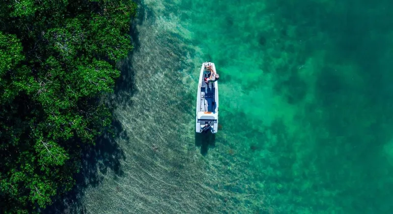 Slide: The Image of Aerial view of a 2024 Veer V13 boat in clear turquoise water near lush greenery. - 7