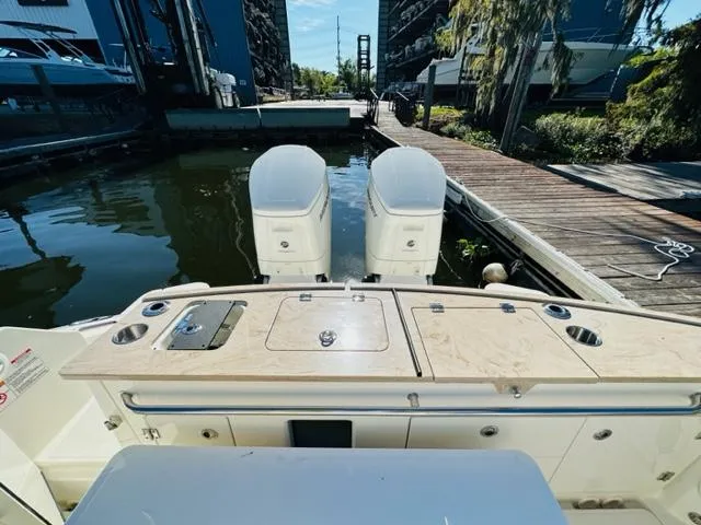 Slide: The Image of 2023 Boston Whaler 360 Outrage at dock with twin outboard engines. - 12