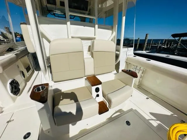 Slide: The Image of 2023 Boston Whaler 360 Outrage boat seating area with cup holders and armrests. - 13