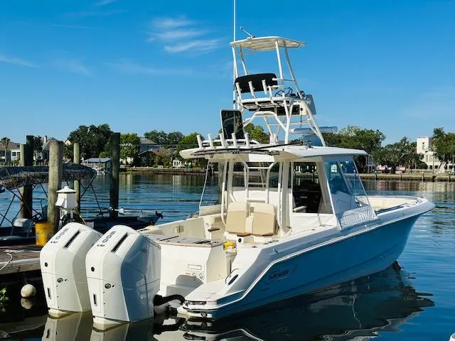 Slide: The Image of 2023 Boston Whaler 360 Outrage boat docked in a marina. - 2