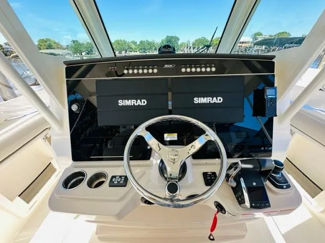 Slide: The Image of 2023 Boston Whaler 360 Outrage helm with dual Simrad displays and steering wheel. - 21